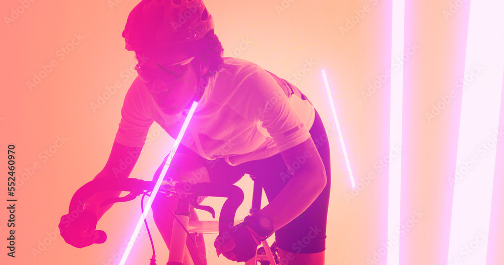 Biracial female athlete wearing eyewear and helmet riding bike over illuminated lines