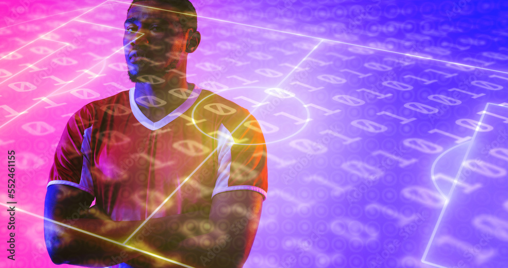 Serious african american male player with arms crossed over illuminated soccer field and binary code