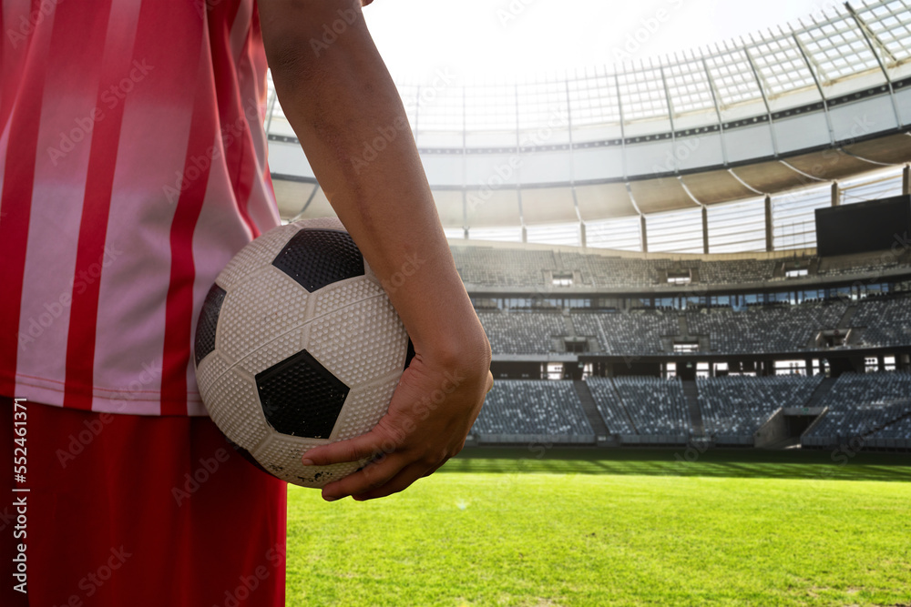 Midsection of player with soccer ball in stadium on sunny day, copy space