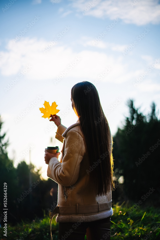 秋天自然中美丽的生活方式女性。美丽年轻迷人的女士在户外玩得很开心。