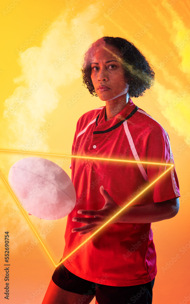 Composite of biracial female rugby player with ball standing amidst smoke by illuminated triangle