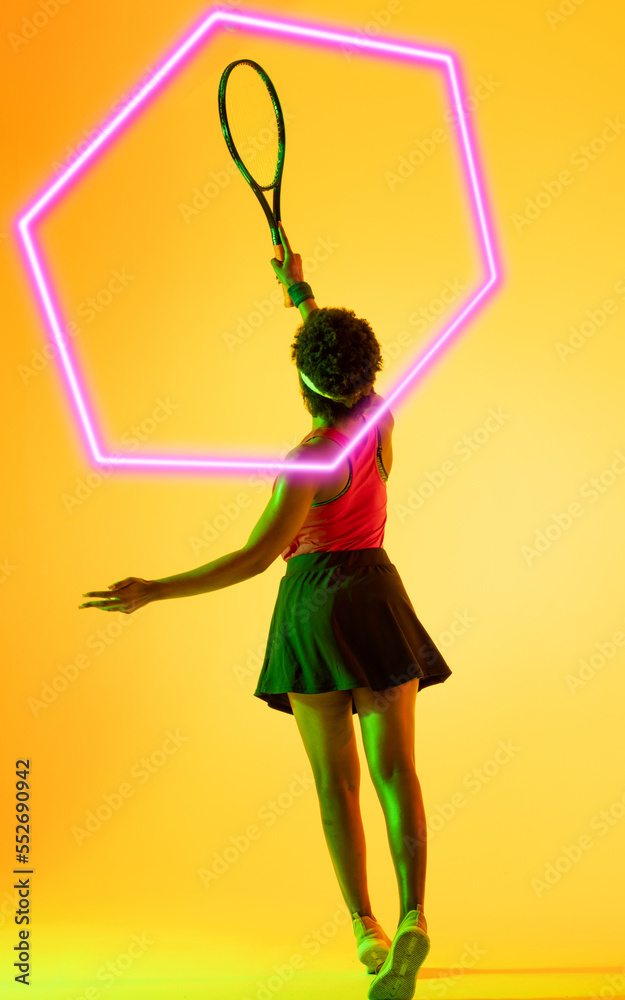 Rear view of african american tennis player with racket and illuminated hexagon on yellow background