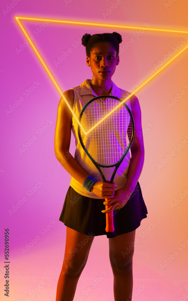 Confident african american female tennis player holding racket by illuminated triangle