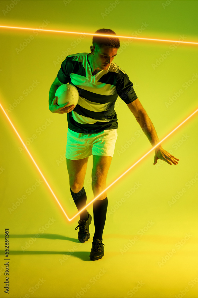 Illuminated triangle over caucasian male player with rugby ball standing over gradient background