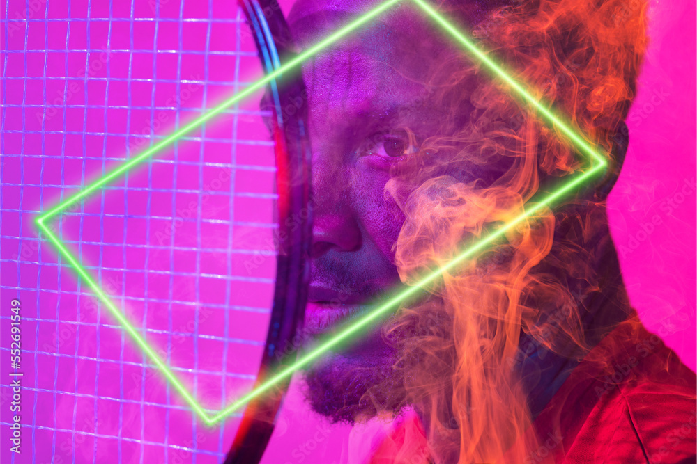 Close-up portrait of african american serious male tennis player with racket by illuminated hexagon