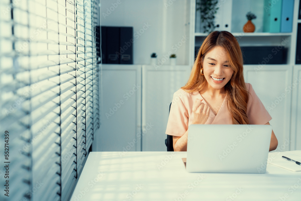 A young female employee receives a promotion, good news or finished her task and overjoyed for being