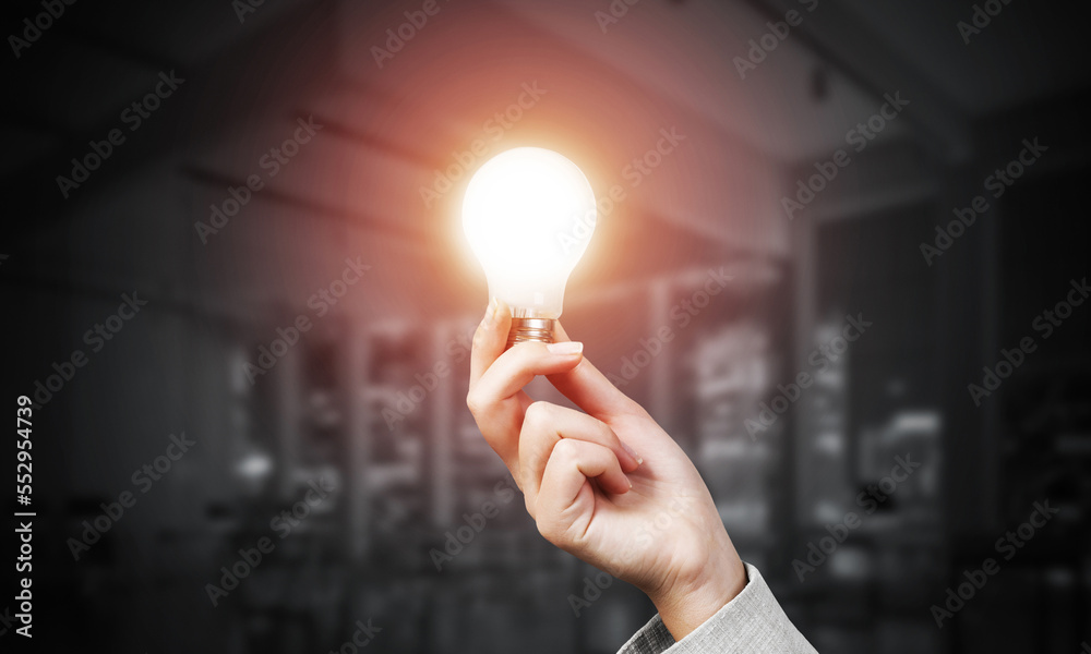 Woman hand with glowing incandescent lamp