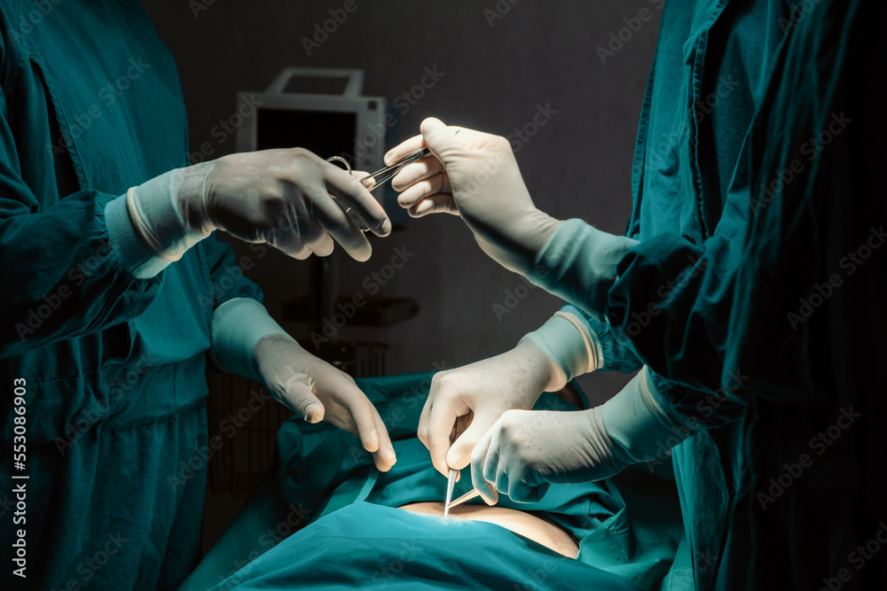 Image of surgical team perform surgery operation, nurse hand out sterile scissors to surgeon as supp