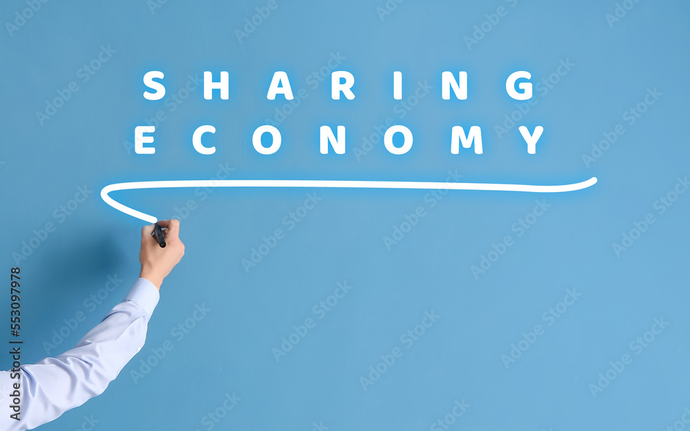 Businessman writing on virtual screen against blue background. Concept of sharing economy