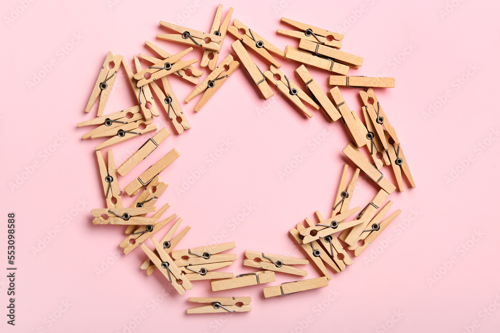 Frame made of wooden clothespins on pink background