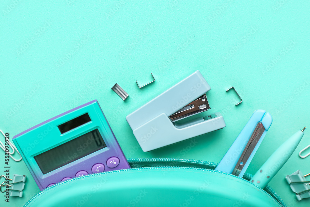 Pencil case with different stationery on turquoise background, closeup