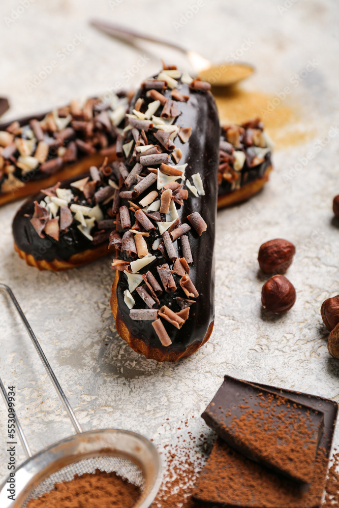 Sweet chocolate eclairs on light background, closeup