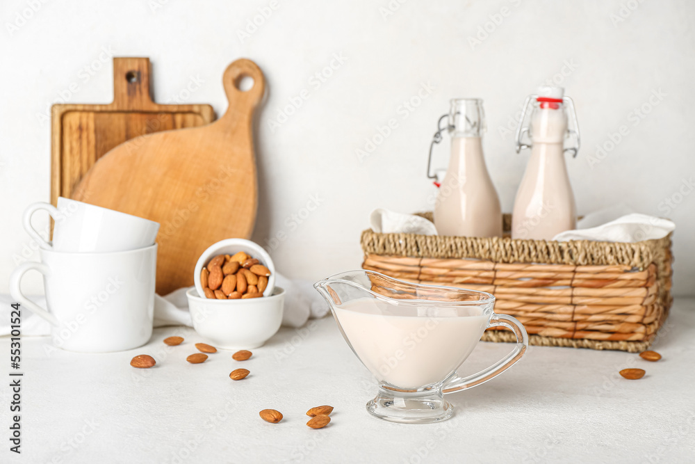 Gravy boat of almond milk on light background