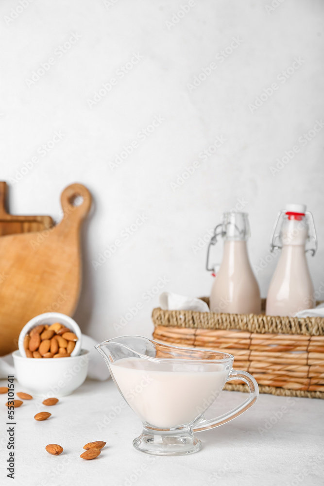 Gravy boat of almond milk on light background