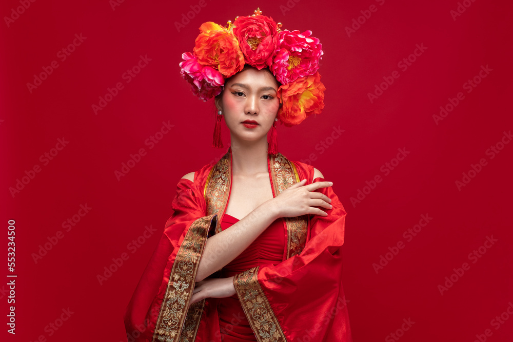 Portrait of young asian woman wearing fashion modern qipao cheongsam dress smile and flower on head 