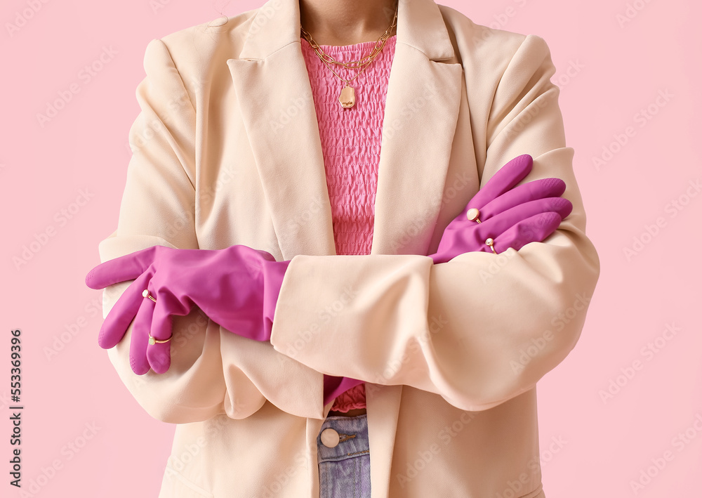 Woman with crossed hands in rubber gloves and jewelry on color background, closeup