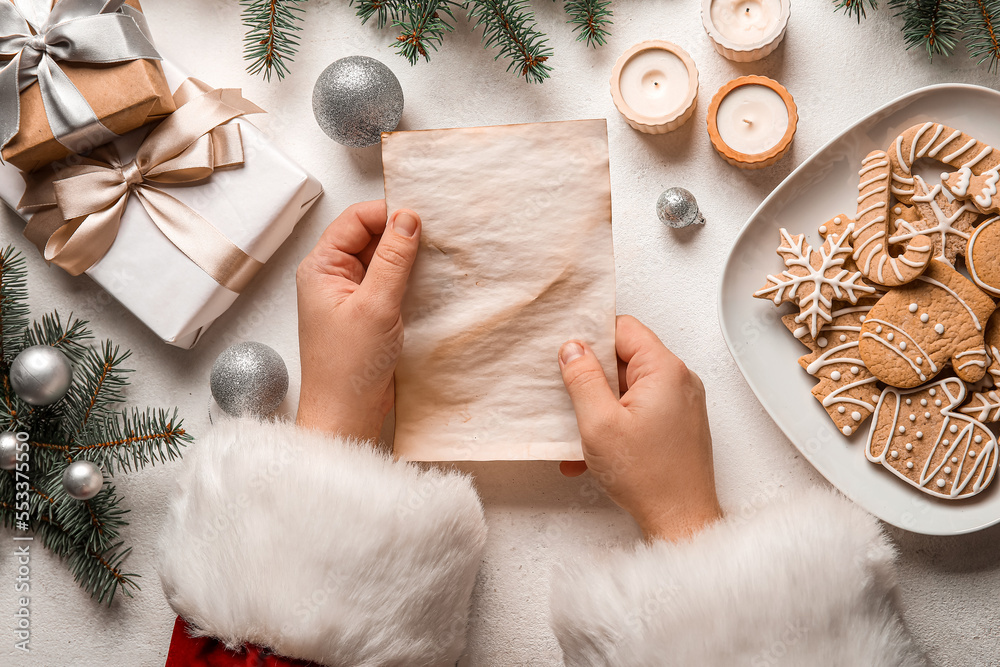 Santa Claus with blank letter, Christmas decor, gifts and cookies on white background