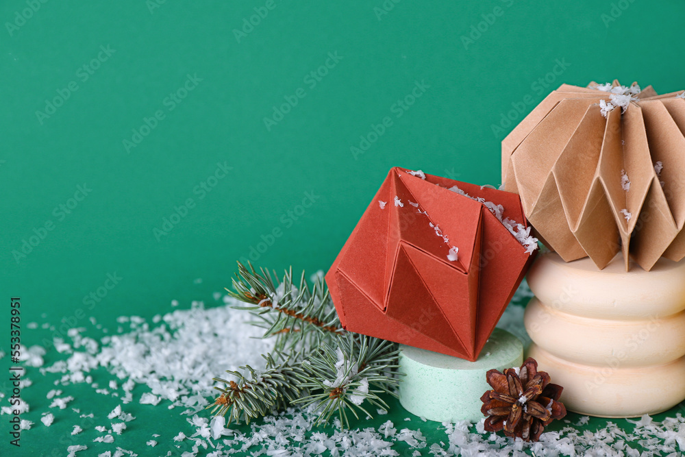 Paper Christmas balls with podiums, fir branches and snow on green background