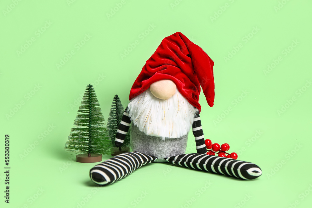 Christmas gnome and decorations on green background