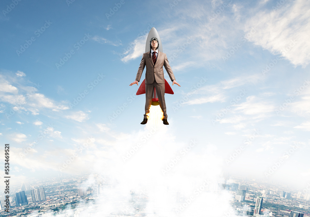 Businessman in aviator hat flying on rocket