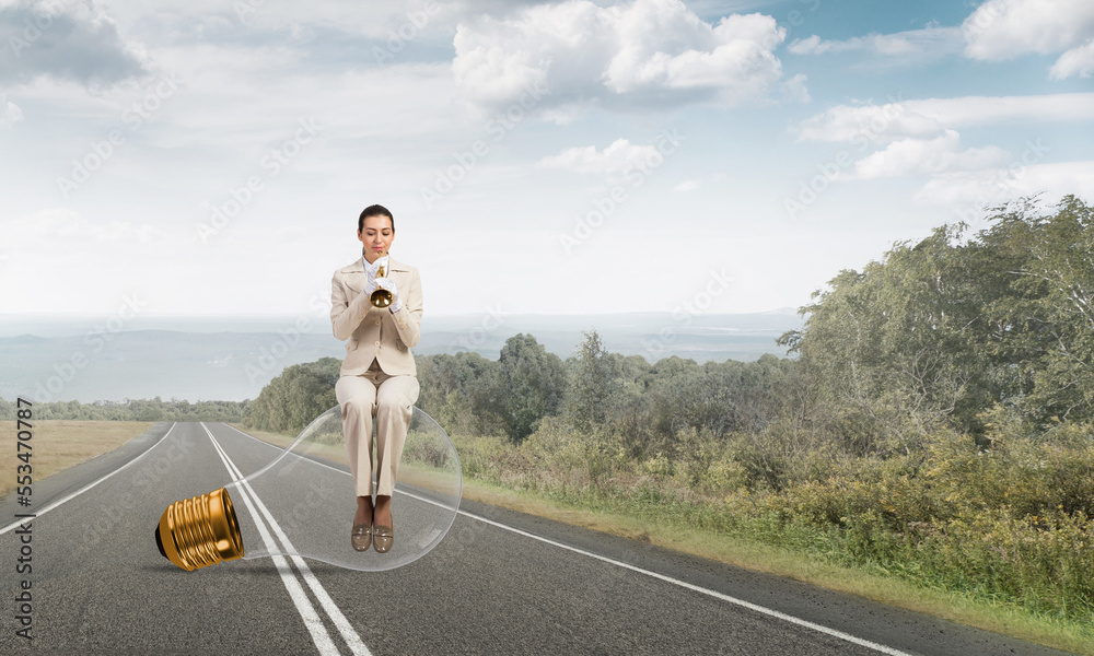 Beautiful woman playing trumpet brass on road