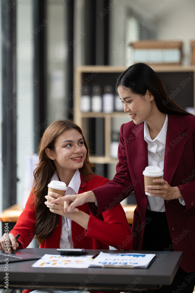 Two beautiful asian business female colleagues interacting while working in office, Business partner