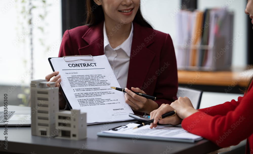 Asian businesswoman making a deal to buy a house or condo inside the office, home insurance concept