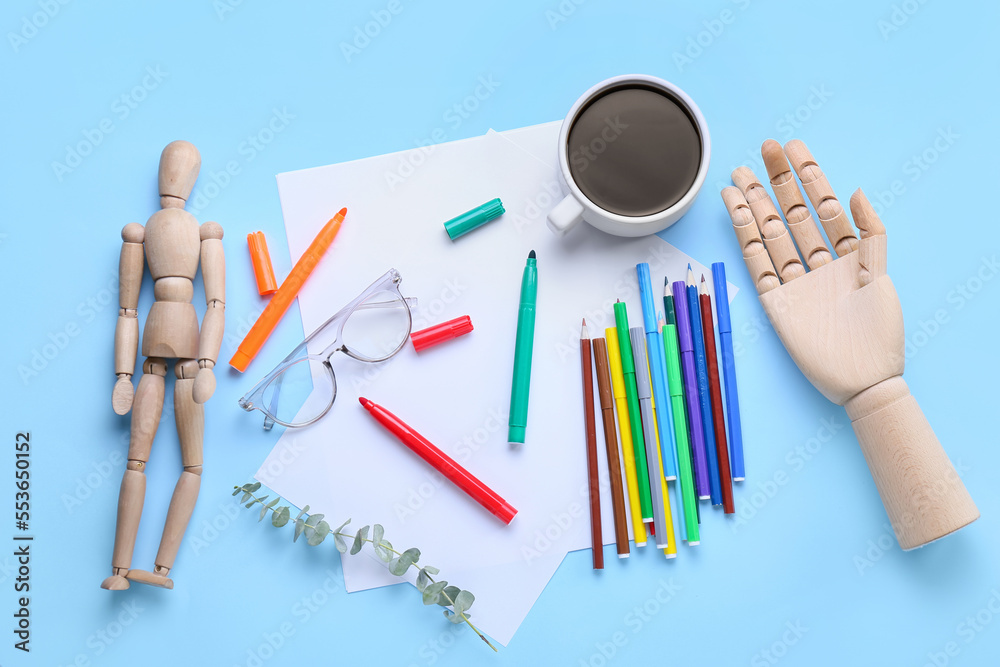 Blank paper sheets with felt-tip pens, pencils, wooden mannequin, eyeglasses and cup of coffee on bl