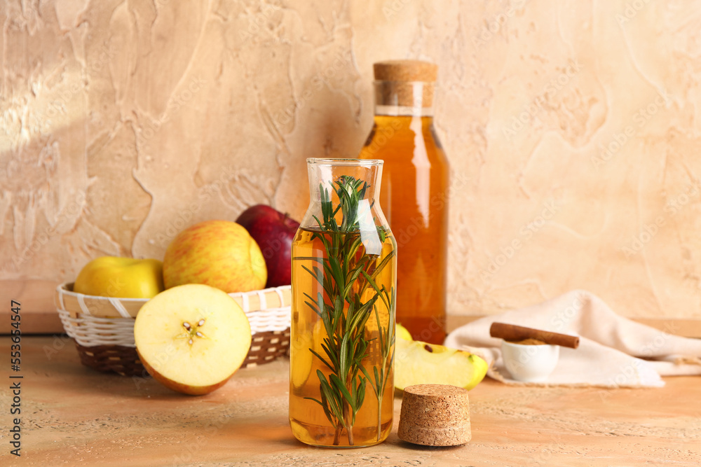 Bottle of fresh apple juice with rosemary on color table