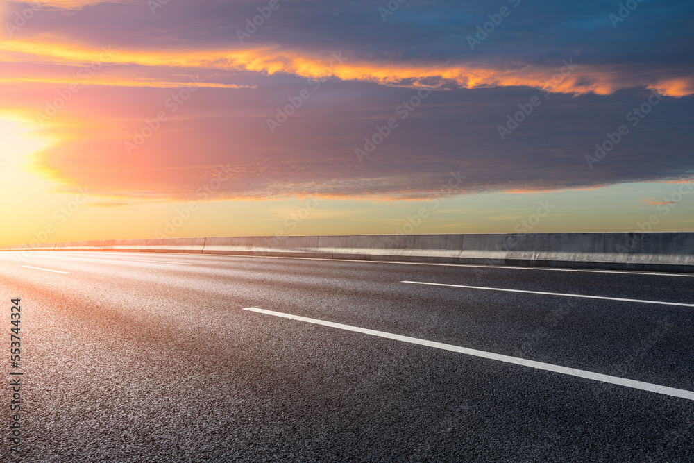 Asphalt road and sky clouds at sunrise. Road and sky background.