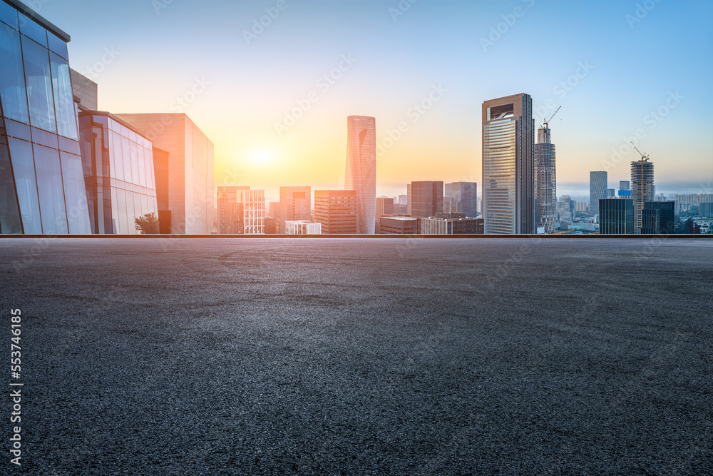 Asphalt road and modern city skyline with buildings at sunset in Ningbo, Zhejiang Province, China.