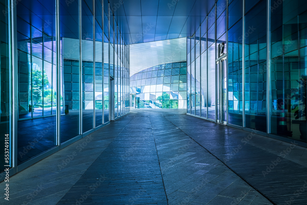 Empty asphalt road and glass wall architectural passageway