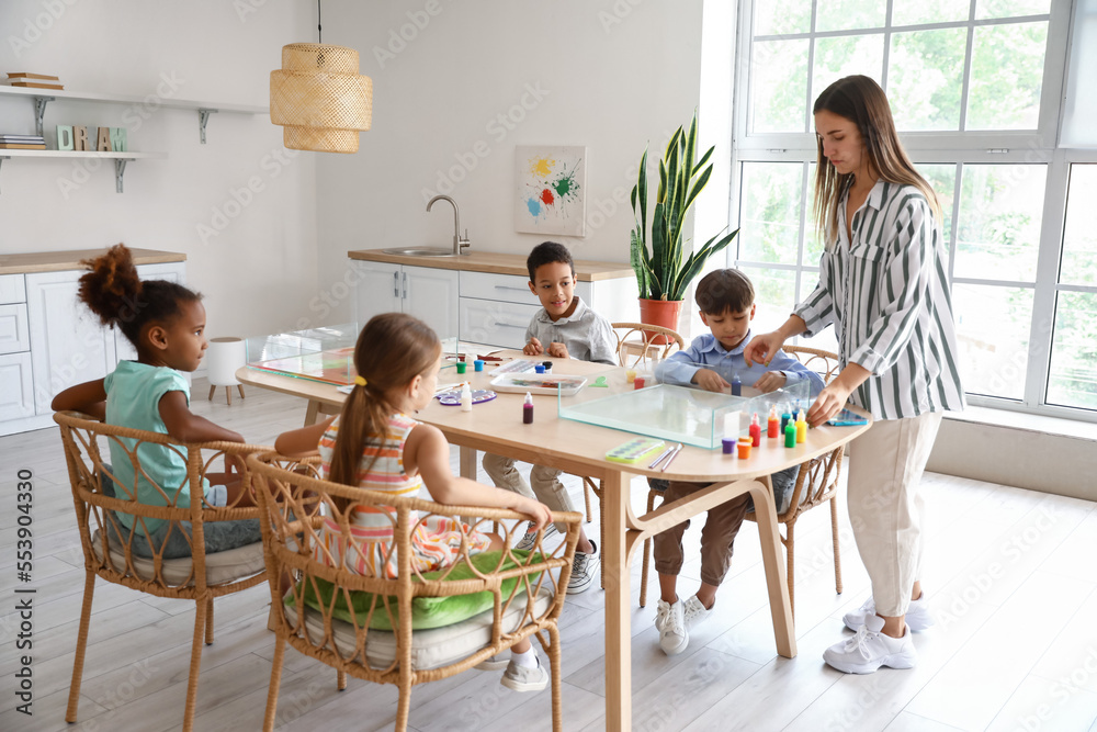 Little children with teacher during master class in Ebru painting at workshop