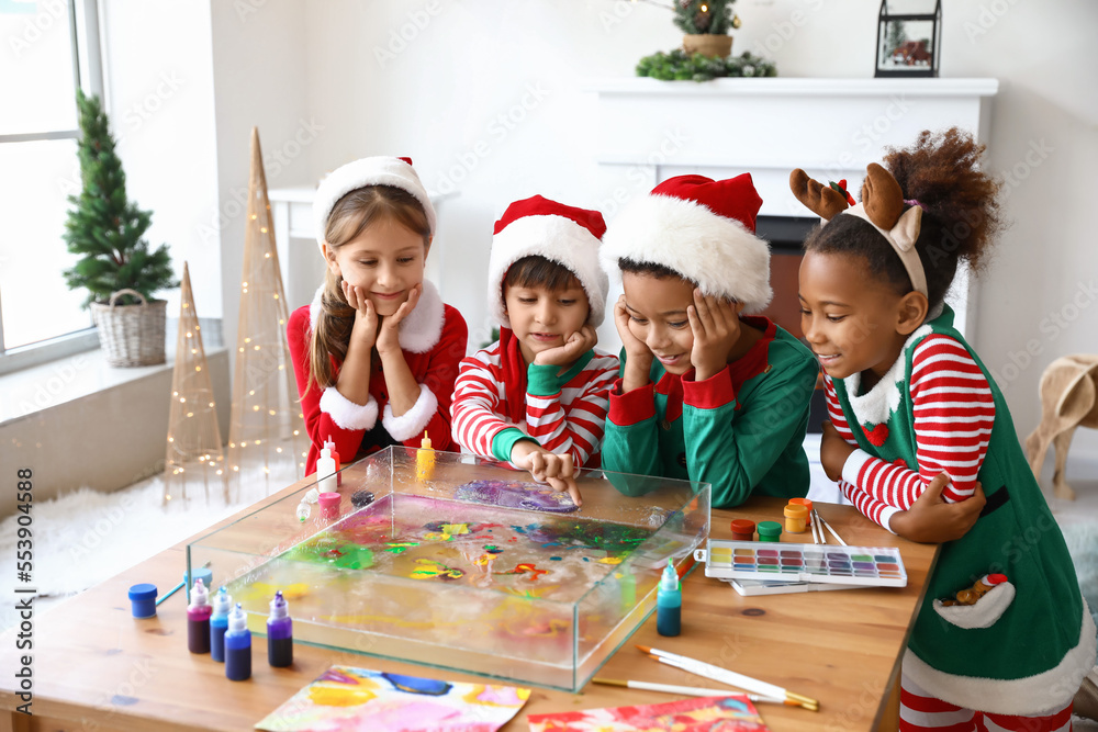 Little children in Christmas costumes at workshop for Ebru painting