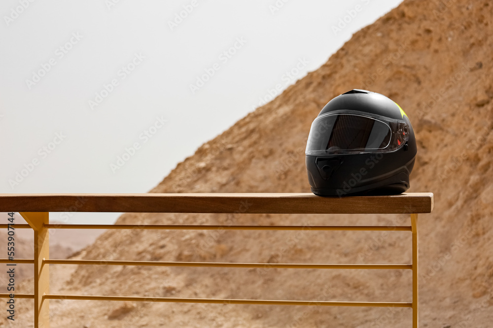 Motorcycle helmet on fence in desert