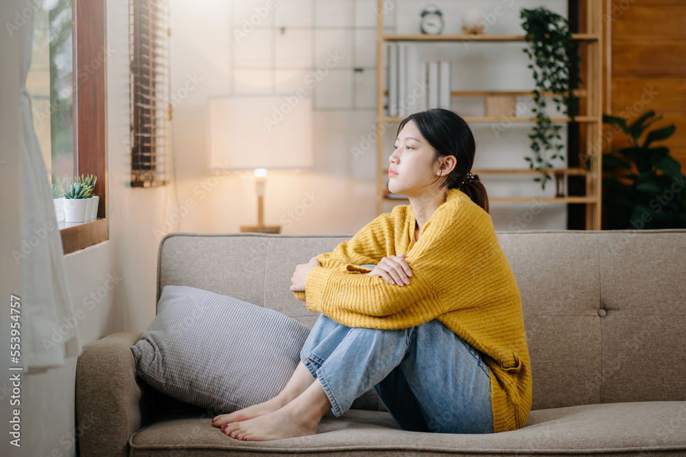 女人坐着沮丧深色头发沉思地瞥了一眼站在窗户边焦虑地复制空间。