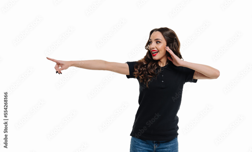 Beautiful woman points to your ad on an isolated white background.  Happy woman against white studio