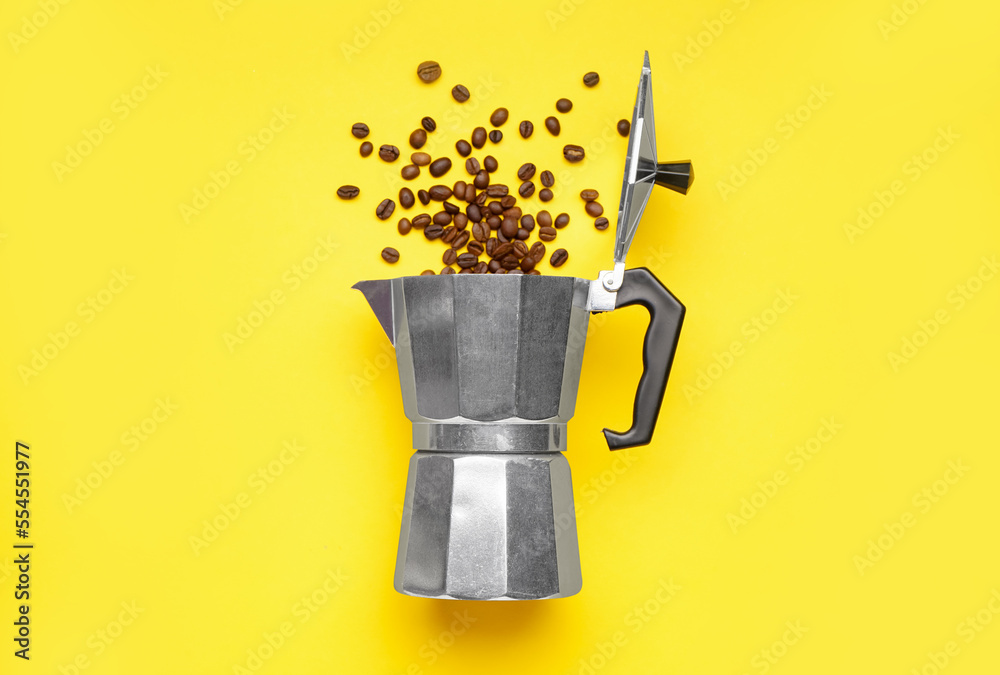 Geyser coffee maker with scattered beans on yellow background