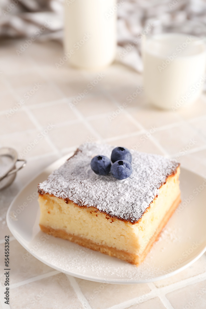 Plate with piece of cheese pie and blueberries on white table