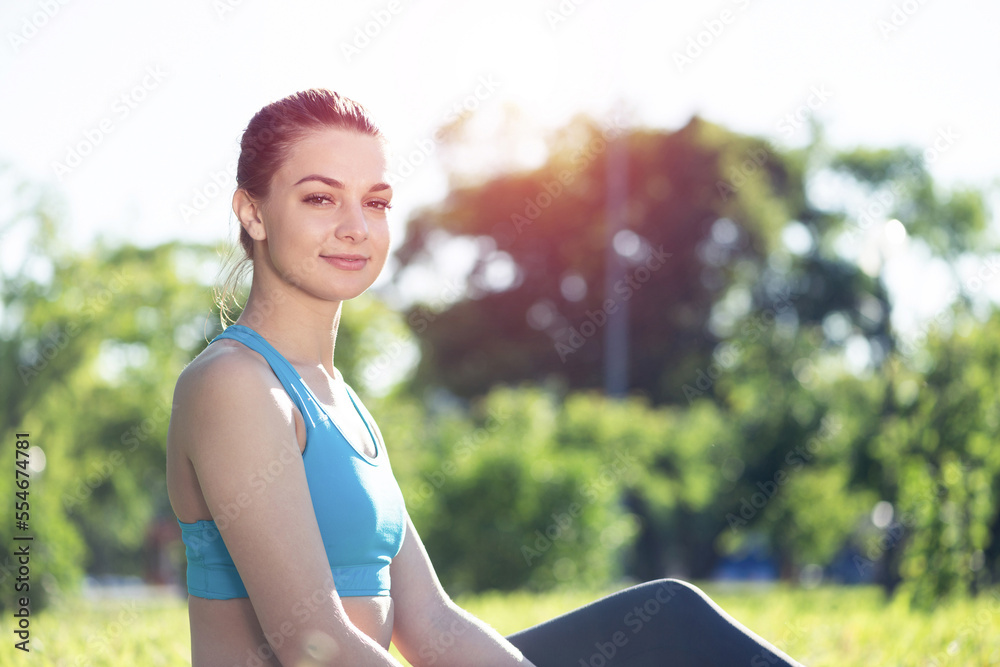 美丽的微笑女孩穿着运动服在公园放松