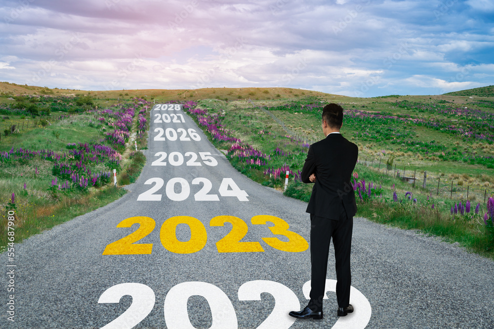 The 2023 New Year journey and future vision concept . Businessman traveling on highway road leading 