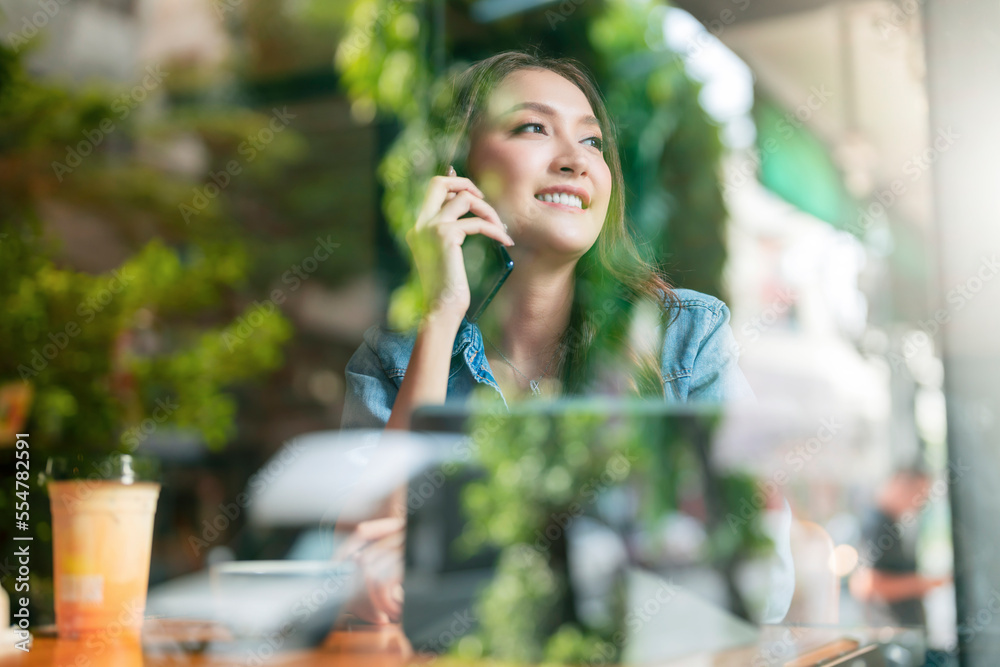 casual smart asian female entrepreneur small business working at coworking space hand using smartpho