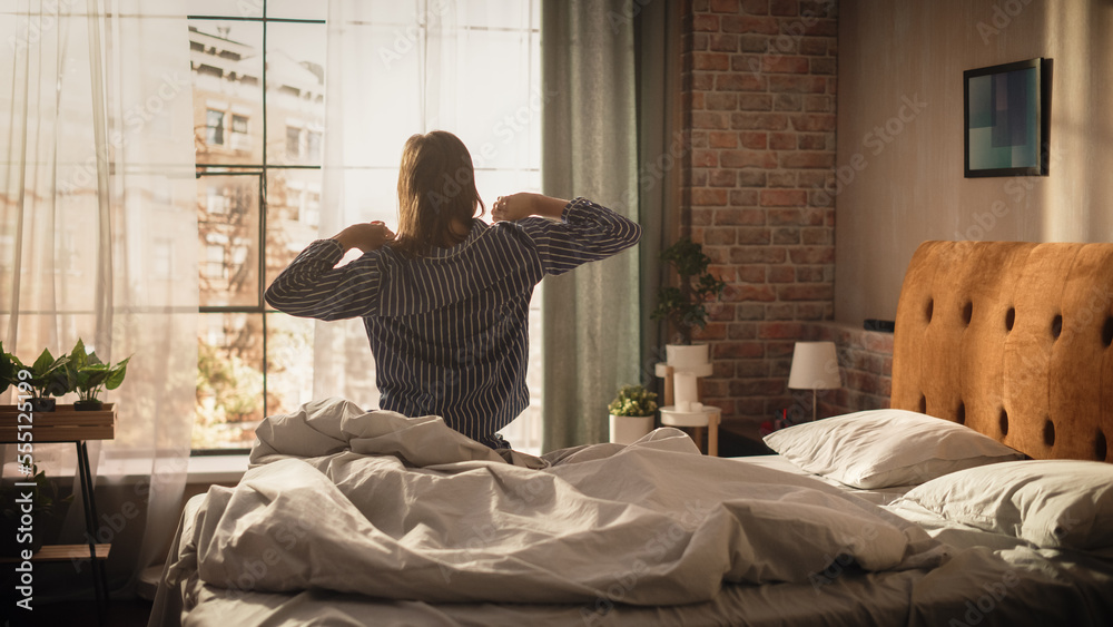 Beautiful Young Woman Waking up in the Morning, Stretches and Gets Out of Bed, Sun Shines From the A