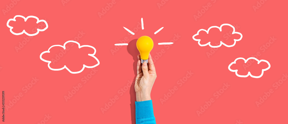 Person holding a yellow light bulb with cloud sketches