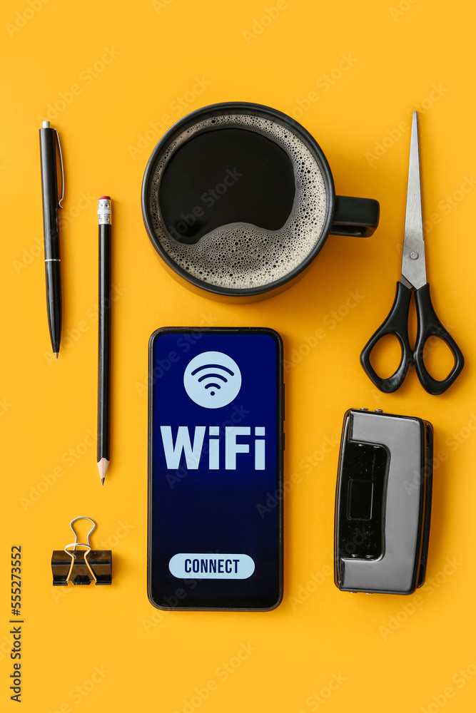 Stationery supplies, cup of coffee and mobile phone with WiFi symbol on color background