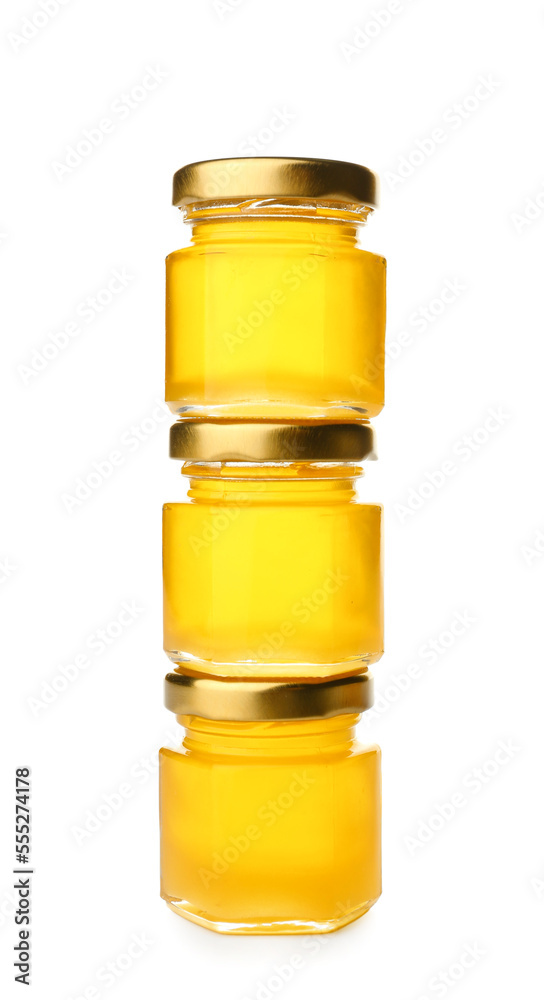 Stack of jars with fresh honey on white background