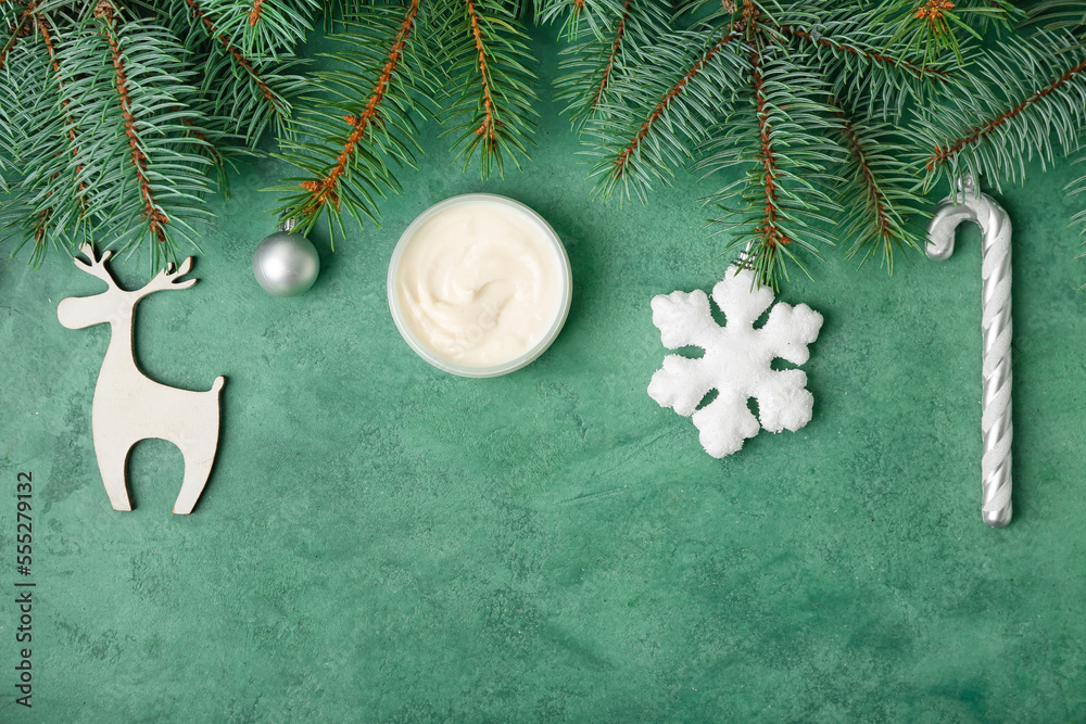 Composition with jar of cream, fir branches and Christmas decorations on color background