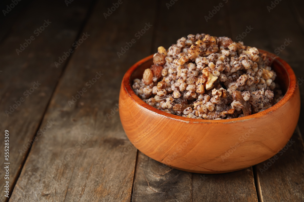 Bowl of Kutya on wooden table, closeup