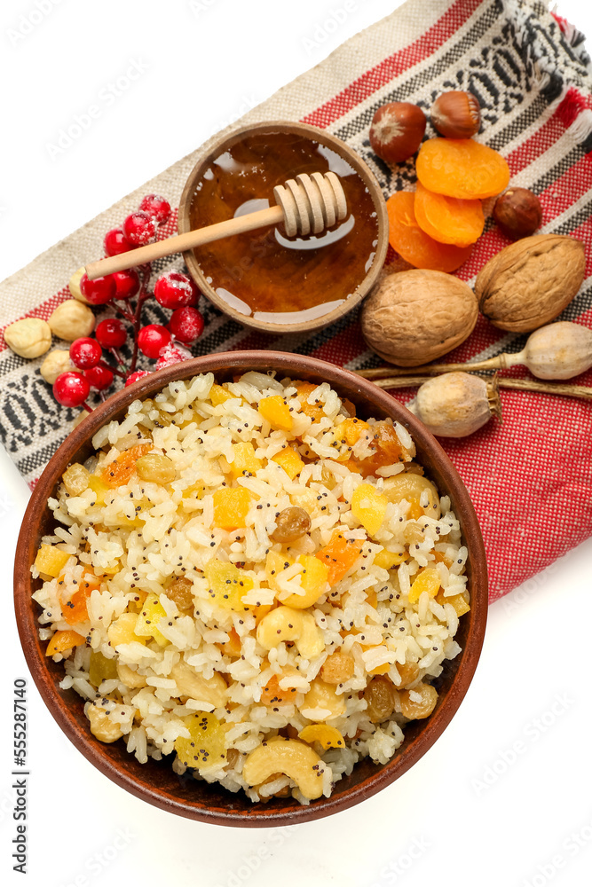 Napkin with bowl of rice Kutya and ingredients on white background