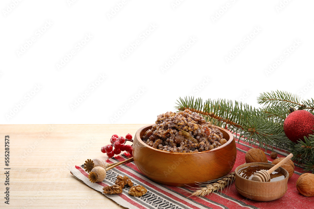 Bowl of Kutya, honey, nuts and Christmas branches on table against white background